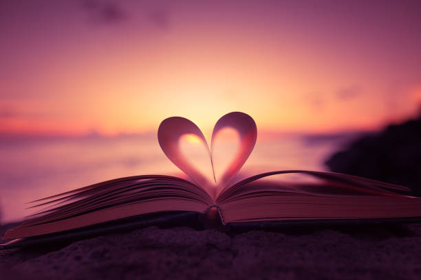 Heart from a book page against a beautiful sunset.